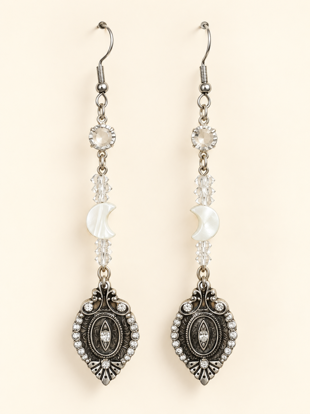 Long silver-tone earrings with clear crystals, mother-of-pearl crescent moons and ornate vintage Art Nouveau charms.